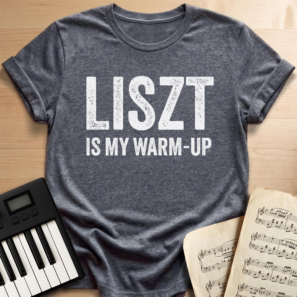 Dark heather tee with bold Liszt Is My Warm-Up print, a brag gift for the introvert pianist.