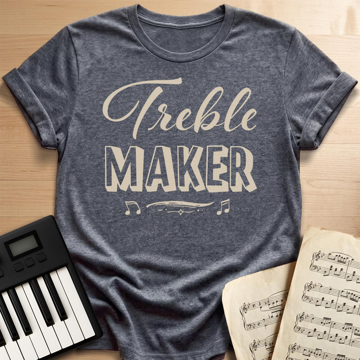 Dark Heather tee with a “Treble Maker” script and block lettering pun with eighth notes, a fun gift for pianists