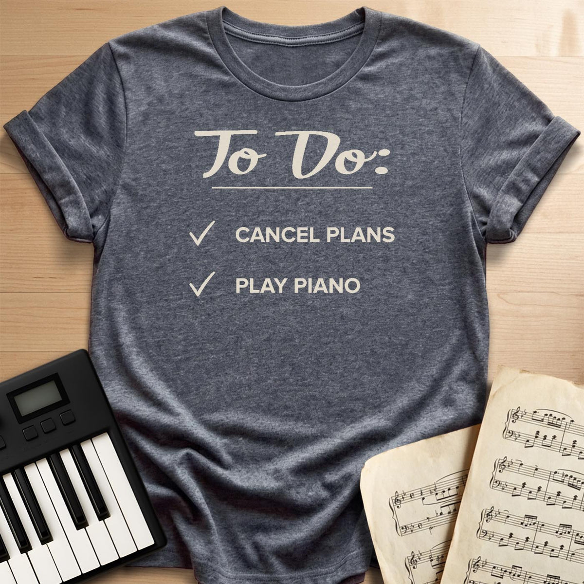 Dark heather grey To Do Cancel Plans Play Piano t-shirt, flat lay with piano keyboard and sheet music
